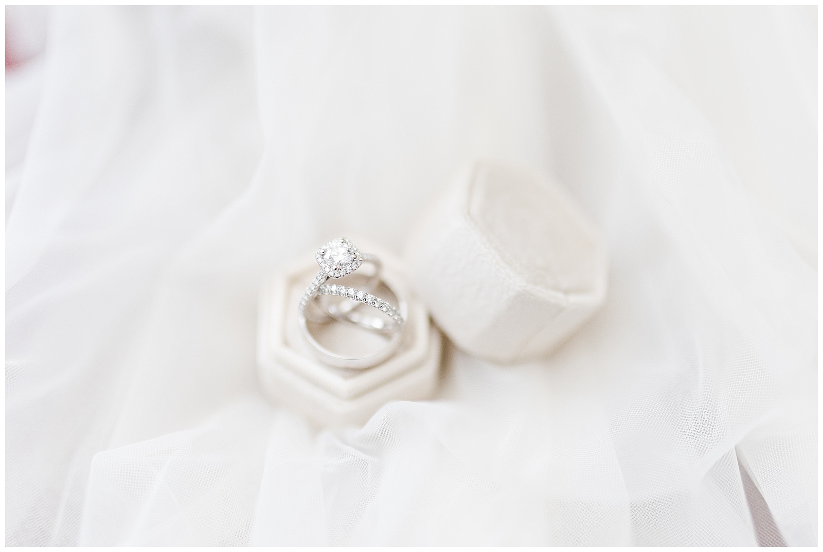wedding rings photographed on layers of white lace in velvet ring box