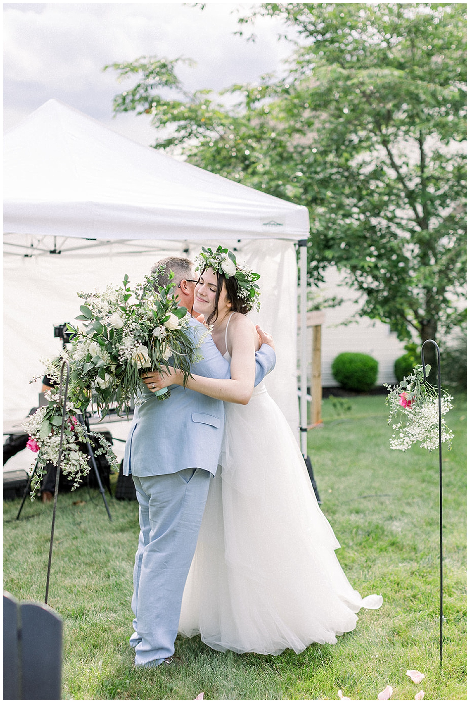 father of the bride gives her a hug before sending her down the aisle at their home wedding ceremony
