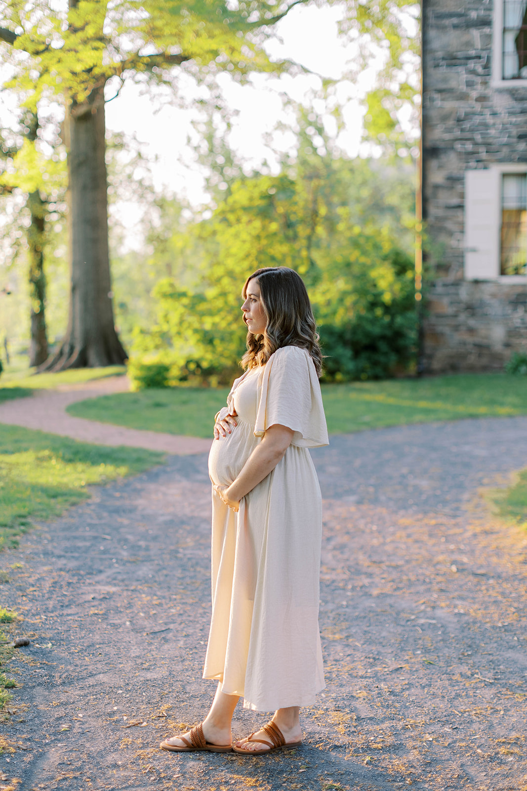 Pregnant woman stands holding her bump at fort hunter mansion and park